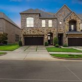 a front view of a house with a yard and trees
