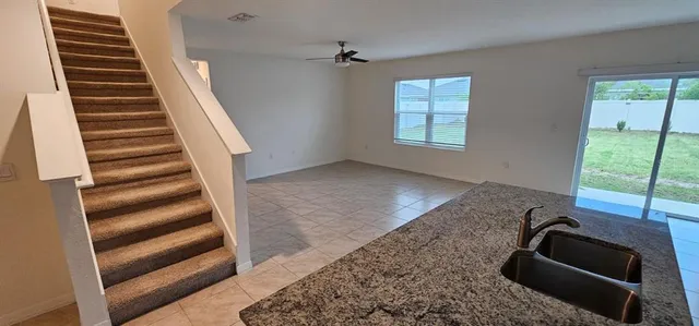 a kitchen with stainless steel appliances granite countertop a refrigerator a sink a stove top oven a counter space and cabinets