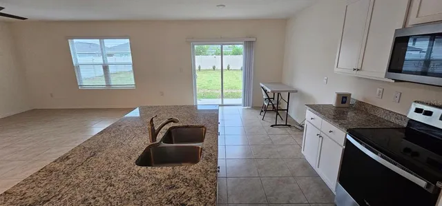 a kitchen with stainless steel appliances granite countertop a refrigerator a stove top oven a sink and dishwasher