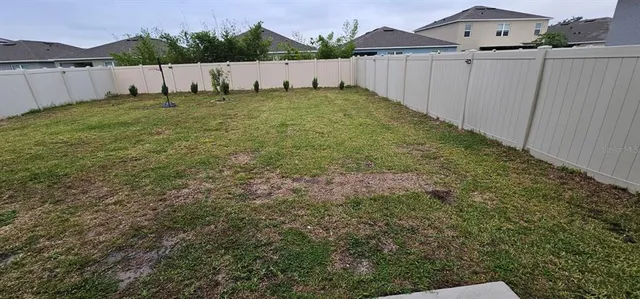 a white house with green field in front of it