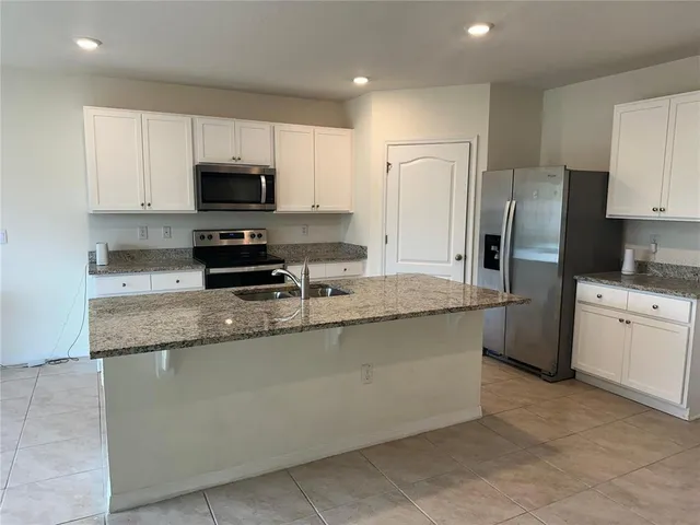 a kitchen with a sink stove top oven and refrigerator