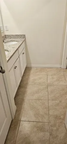 an empty room with a chandelier fan and windows