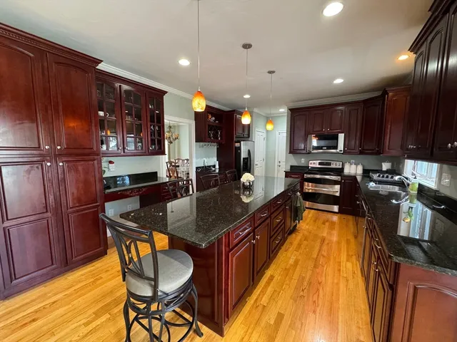 a kitchen with stainless steel appliances granite countertop wooden cabinets a stove top oven a sink and dishwasher