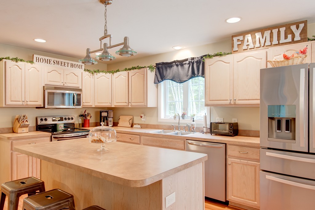 6 Vinton Road Sturbridge, MA 01566 - Photo 8 of 20 a kitchen with stainless steel appliances a sink a stove a refrigerator cabinets and a window