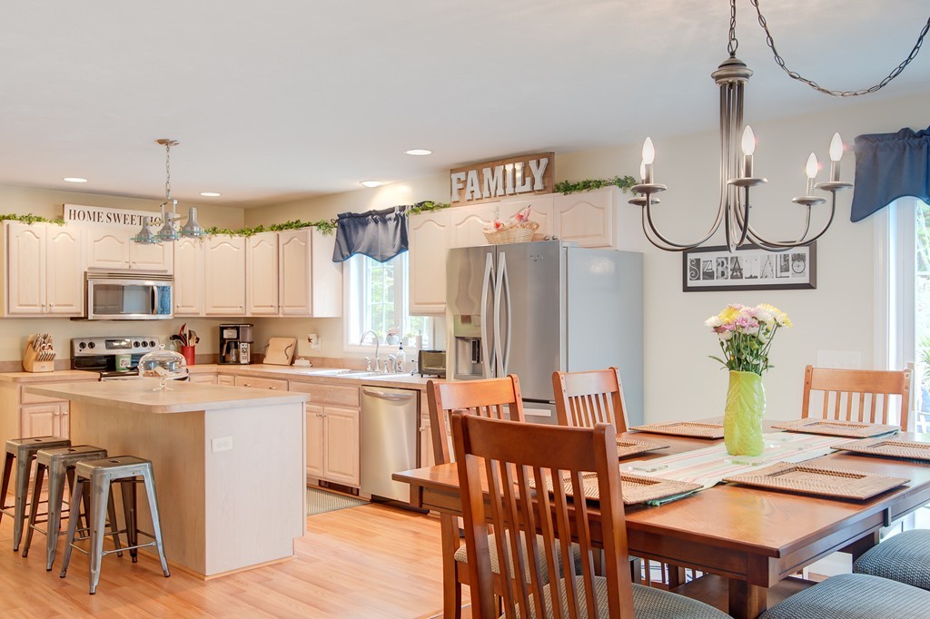 6 Vinton Road Sturbridge, MA 01566 - Photo 9 of 20 a kitchen with stainless steel appliances a dining table chairs refrigerator and sink