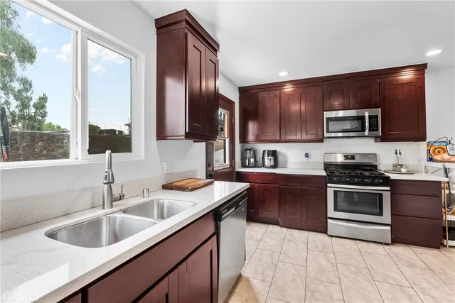 a kitchen with stainless steel appliances granite countertop a sink stove microwave and refrigerator