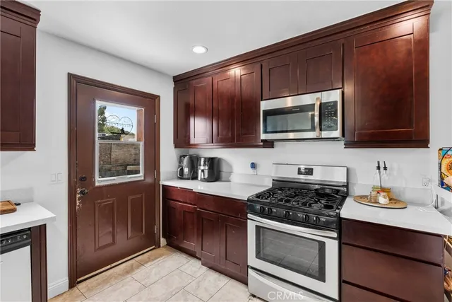 a kitchen with stainless steel appliances a stove microwave and sink