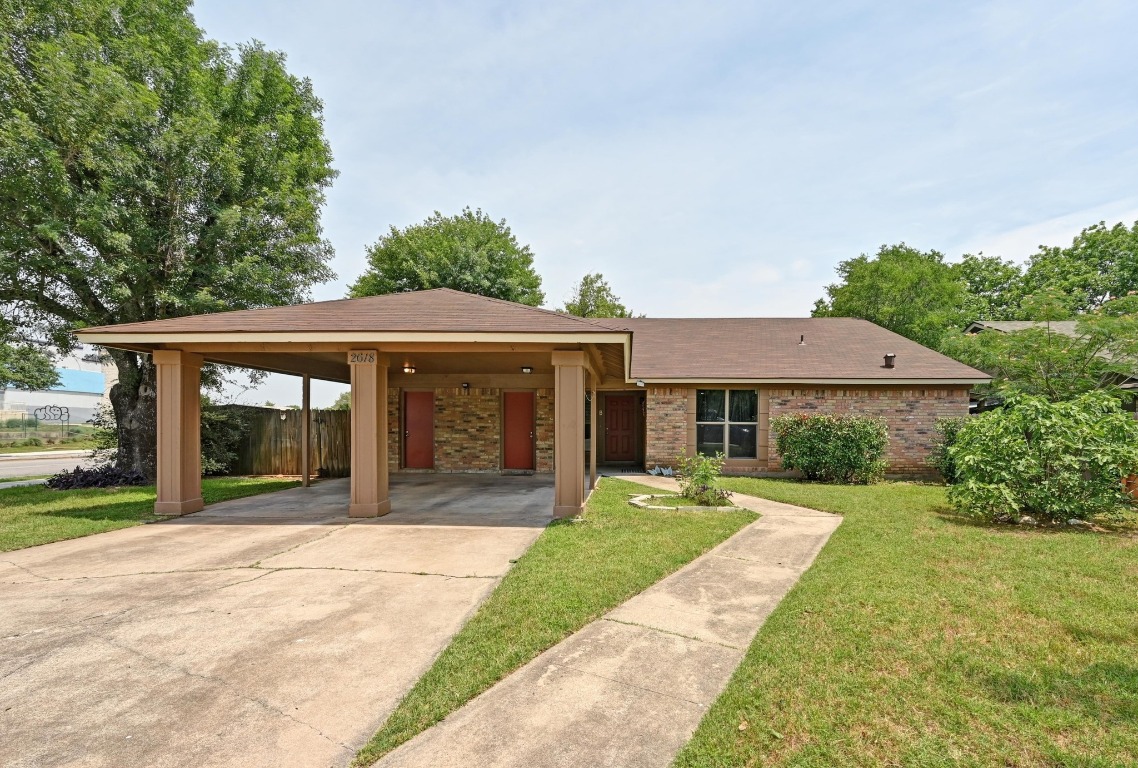 a front view of a house with a yard and potted plants