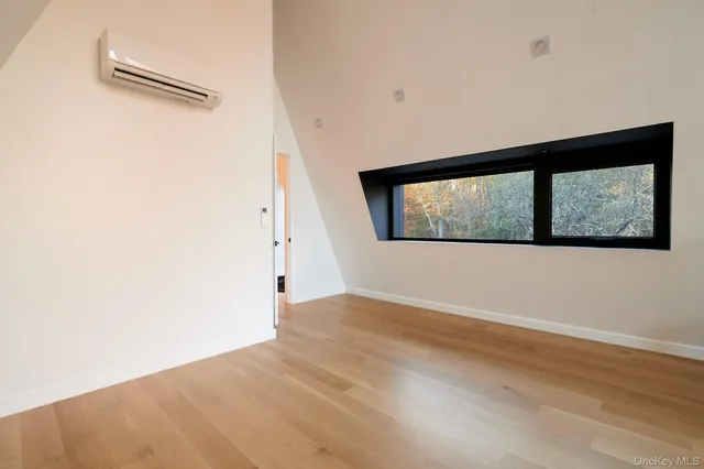 a view of a big room with wooden floor and windows
