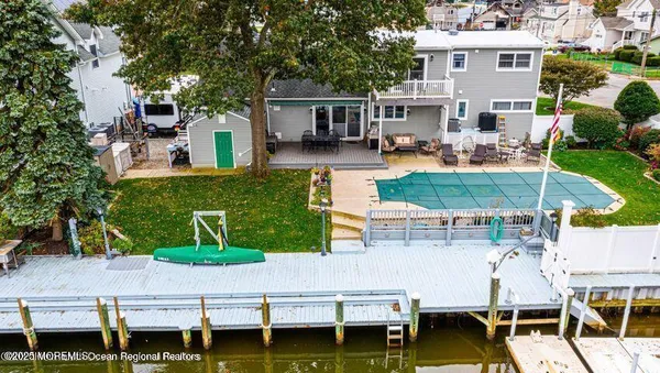 an aerial view of a house with swimming pool and outdoor seating