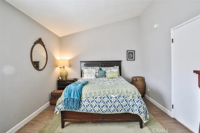 a bedroom with a bed a mirror and a lamp on the table