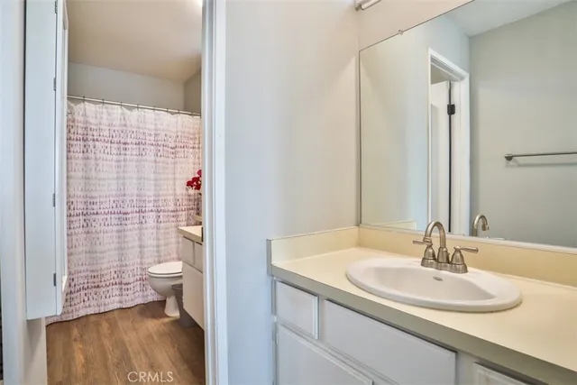 a bathroom with a sink a toilet and shower curtain
