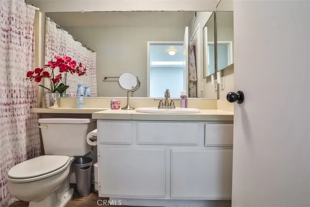 a bathroom with a sink vanity mirror and toilet