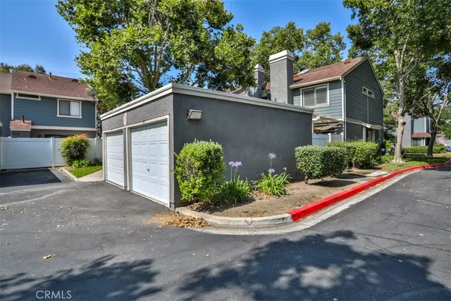 a view of a house with a yard and large tree