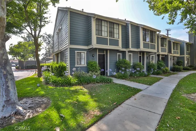 a front view of a house with garden and trees