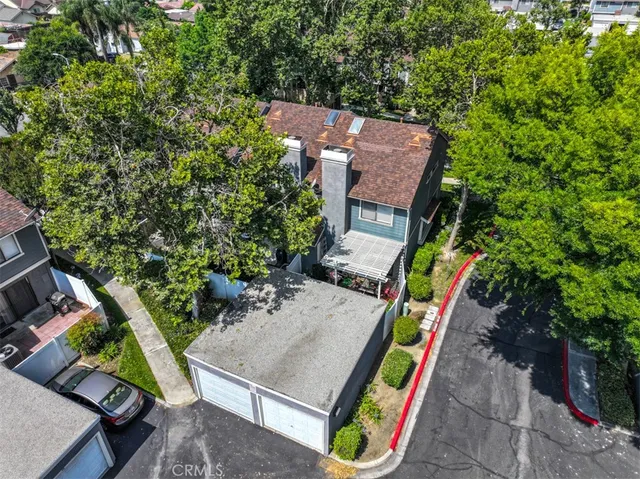 an aerial view of a house with swimming pool and large trees