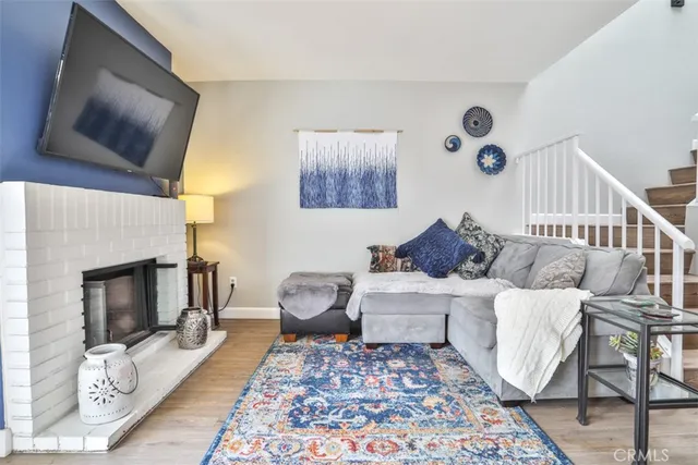 a living room with furniture a flat screen tv and a fireplace
