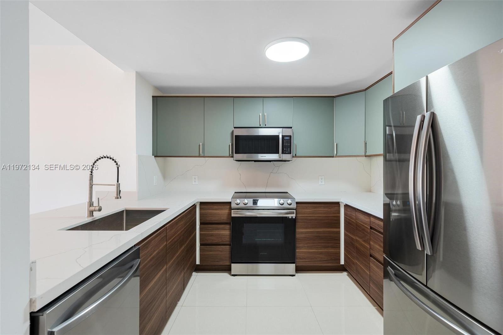 2280 Southwest 32nd Avenue, Unit 201 Miami, FL 33145 - Photo 4 of 23 a kitchen with stainless steel appliances a stove a sink and a refrigerator