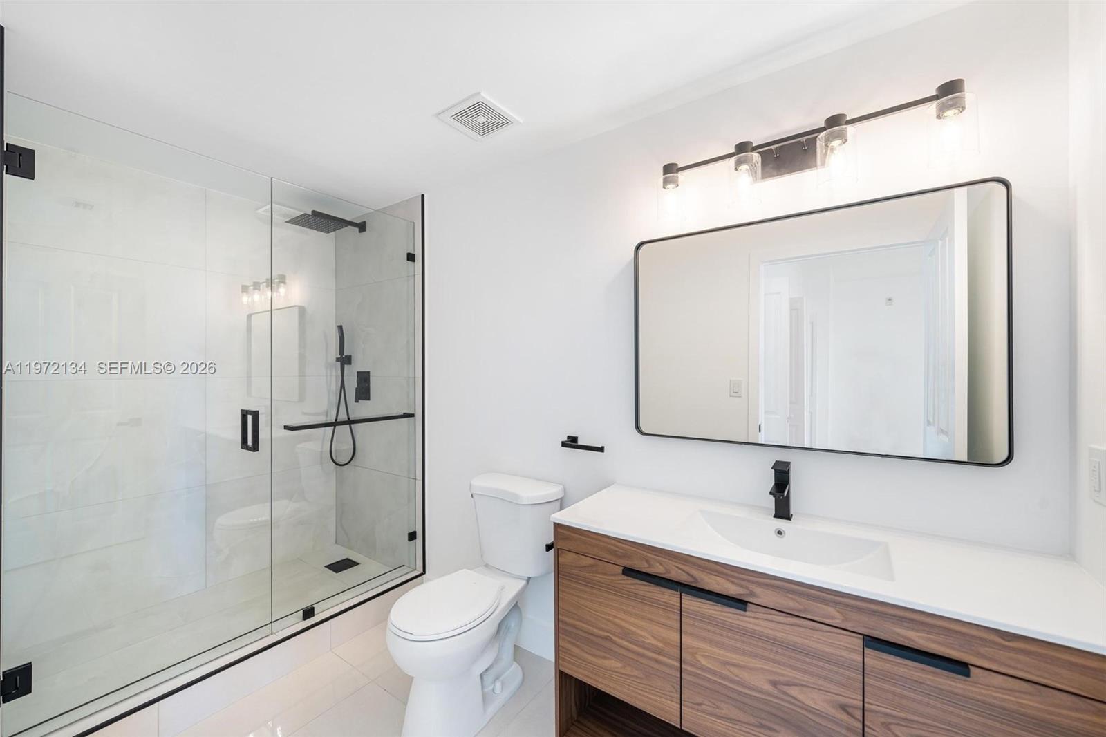 2280 Southwest 32nd Avenue, Unit 201 Miami, FL 33145 - Photo 7 of 23 a bathroom with a double vanity sink mirror and toilet