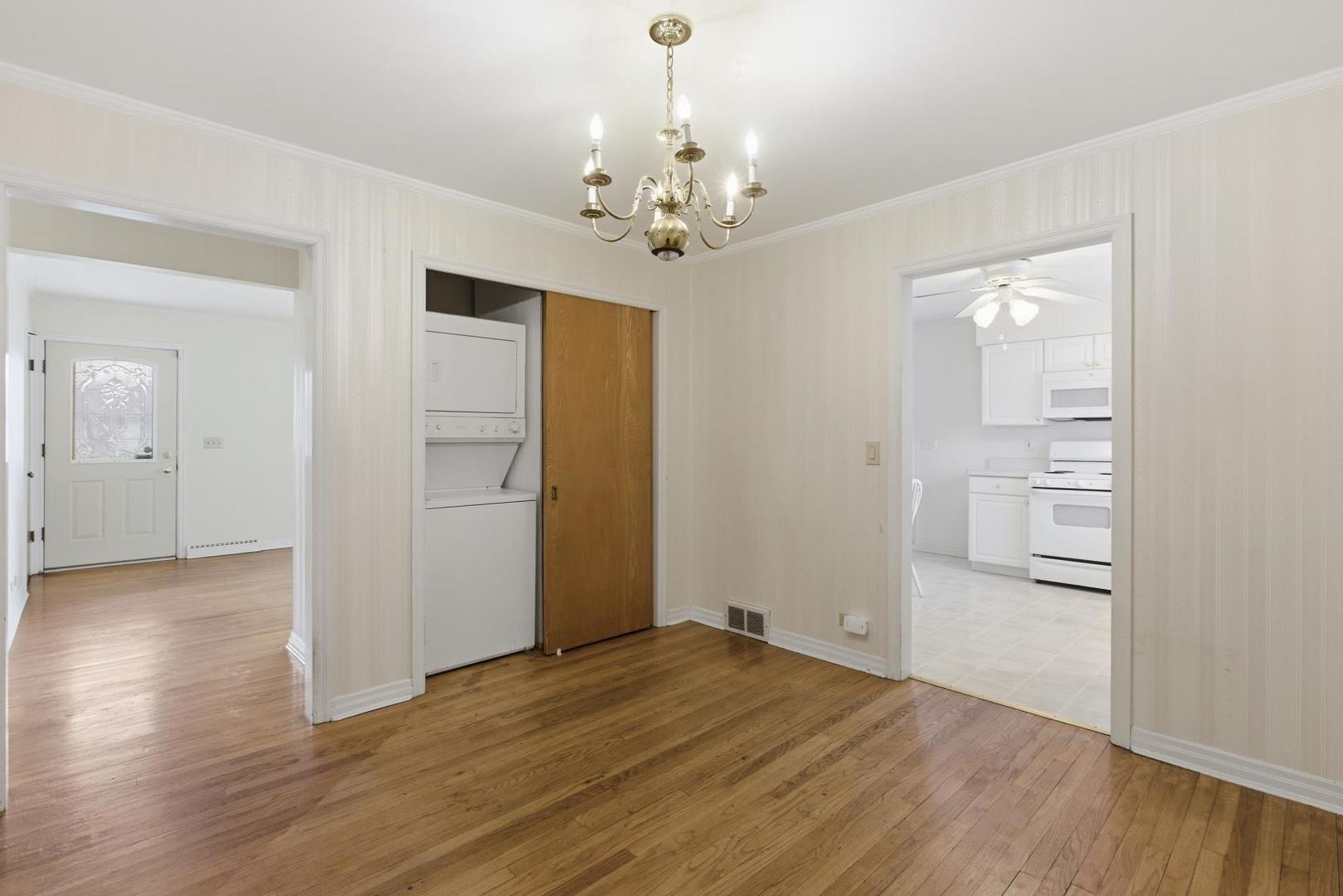 700 Ford Avenue Elgin, IL 60120 - Photo 9 of 20 an empty room with wooden floor chandelier and windows