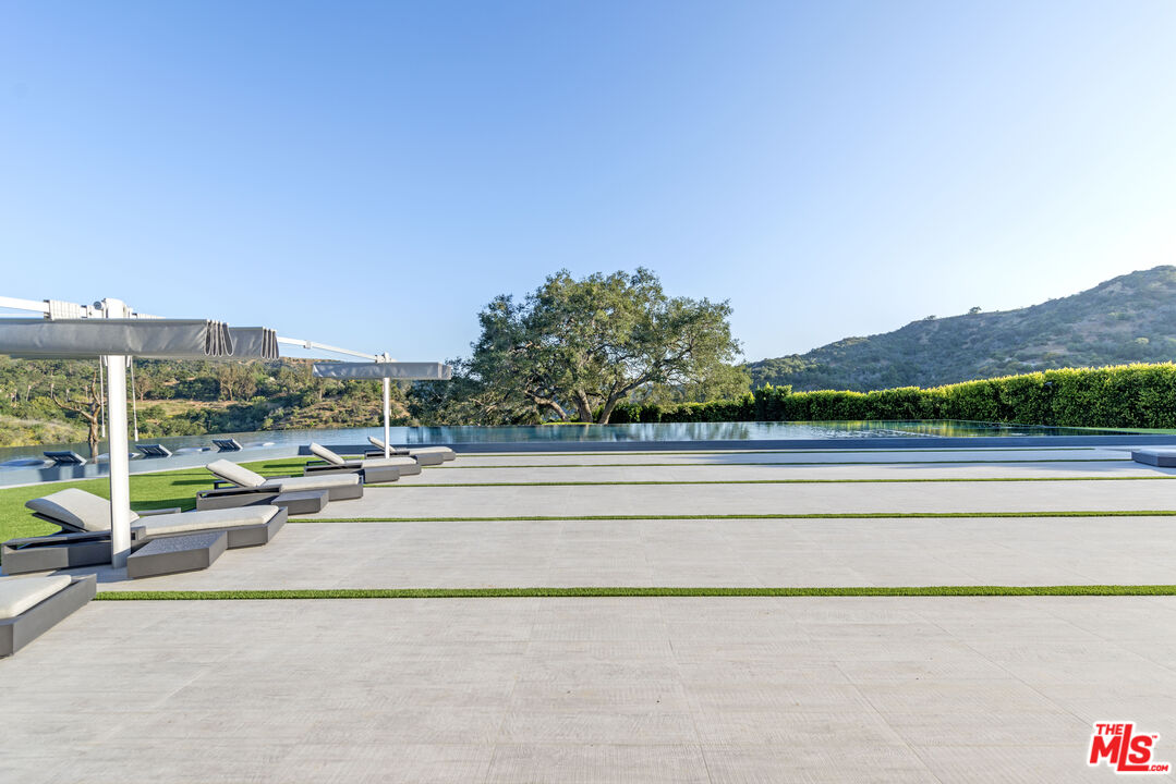 2571 Wallingford Drive Beverly Hills, CA 90210 - Photo 16 of 23 a view of a terrace with a bench and chairs