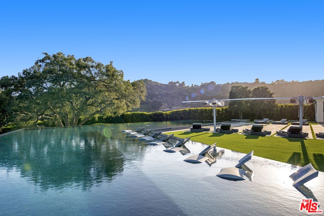 2571 Wallingford Drive Beverly Hills, CA 90210 - Photo 17 of 23 a view of a swimming pool with lounge chairs
