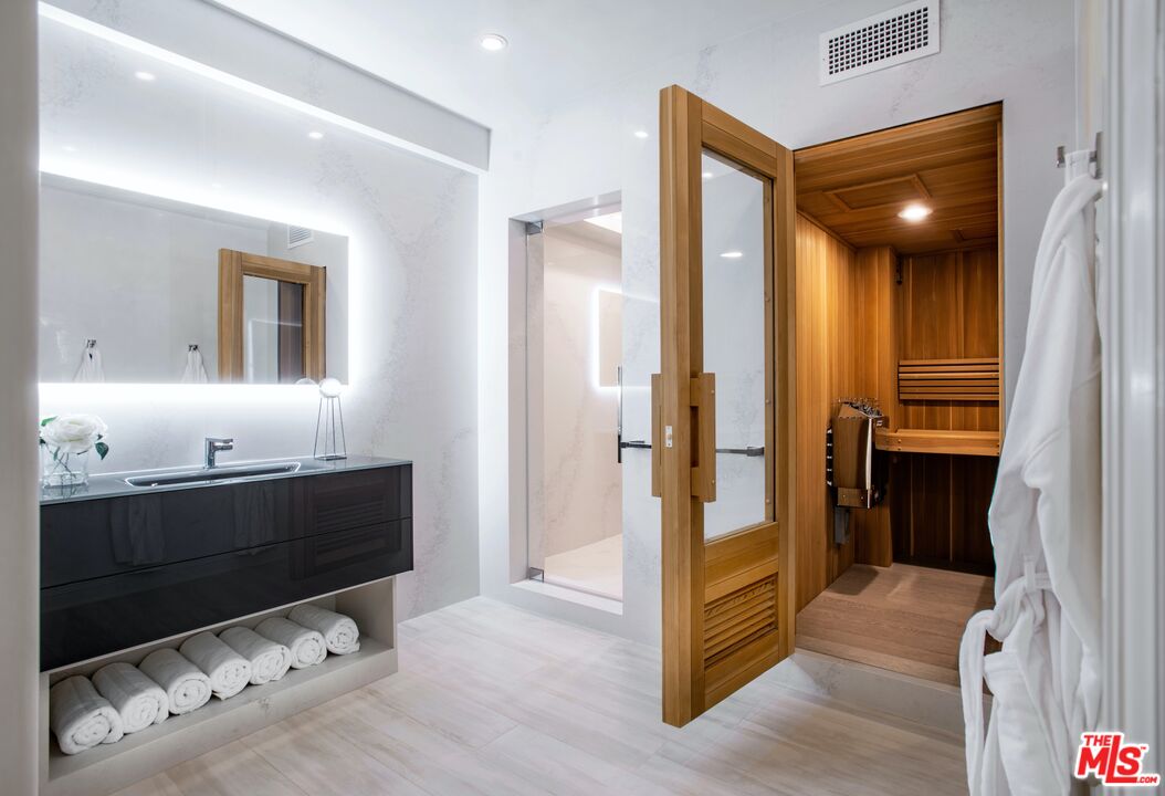 2571 Wallingford Drive Beverly Hills, CA 90210 - Photo 10 of 23 a bathroom with a double vanity sink a mirror and a bathtub
