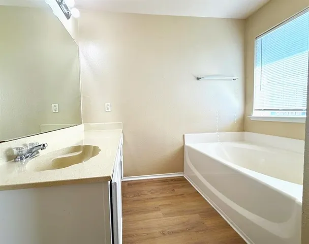 a bathroom with a tub shower and sink