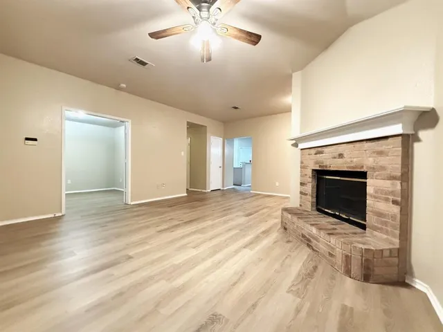 a view of empty room with wooden floor and fireplace