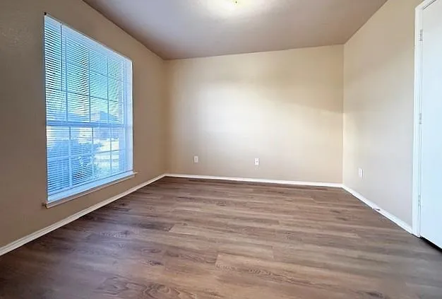 wooden floor in an empty room with a window