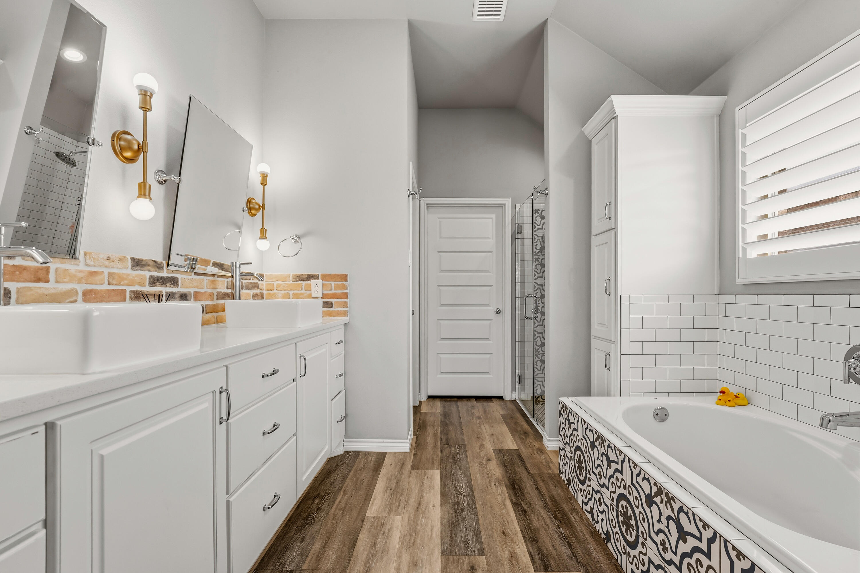 3611 133rd Street Lubbock, TX 79423 - Photo 19 of 31 a bathroom with a tub a sink and a mirror