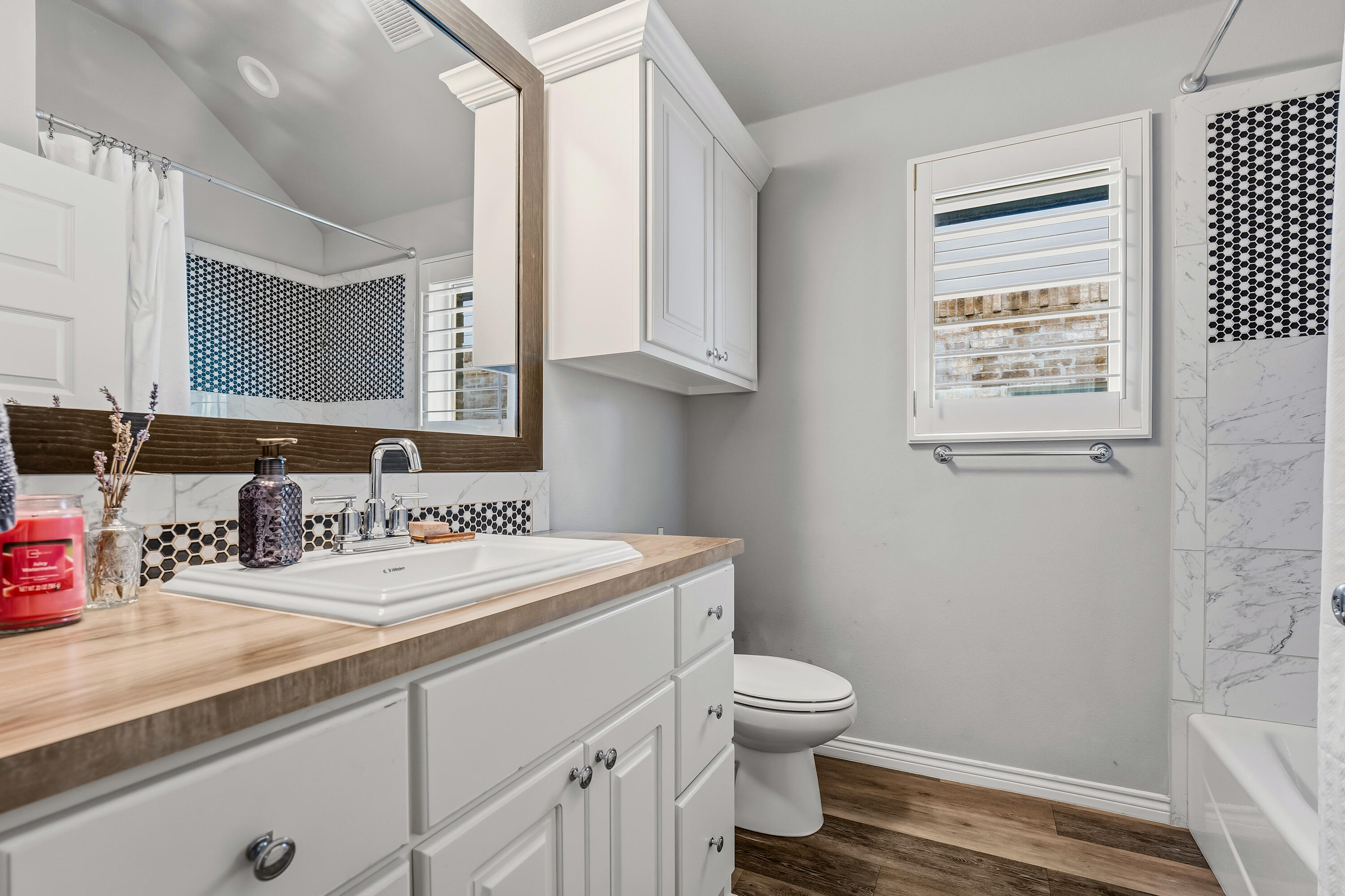3611 133rd Street Lubbock, TX 79423 - Photo 28 of 31 a bathroom with a sink a toilet and a mirror
