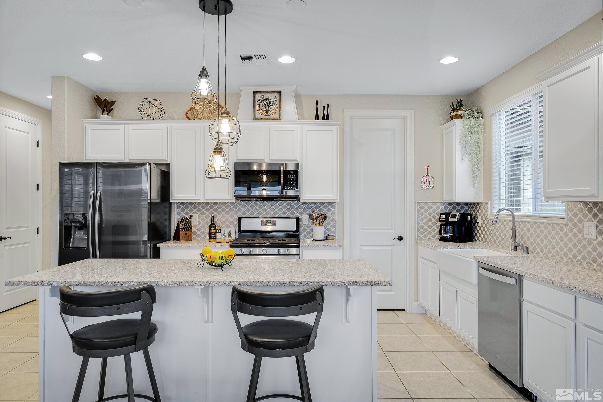 3300 Show Jumper Lane Reno, NV 89521 - Photo 15 of 40 a kitchen with stainless steel appliances a sink a stove a refrigerator cabinets and chairs