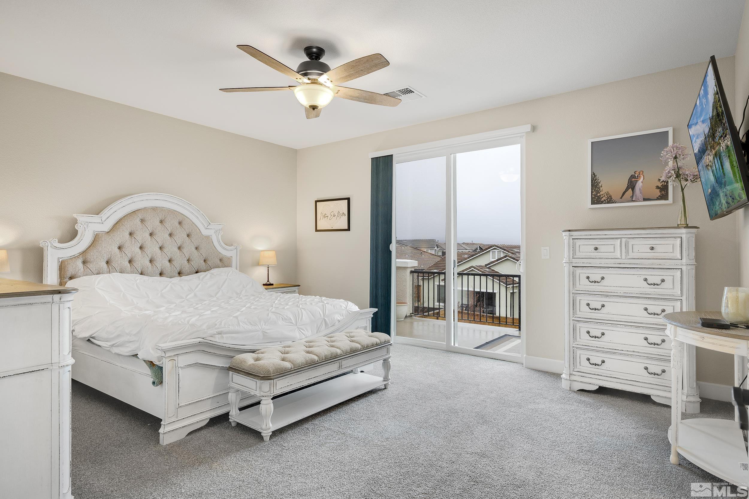 3300 Show Jumper Lane Reno, NV 89521 - Photo 17 of 40 a spacious bedroom with a bed a dresser and a chandelier
