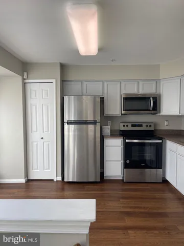 a kitchen with granite countertop a refrigerator stove and microwave