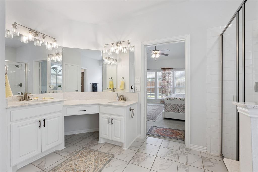 Undisclosed Address Wylie, TX 75098 - Photo 15 of 26 Primary bathroom featuring marble look tiles, double vanity, a shower stall, and a ceiling fan