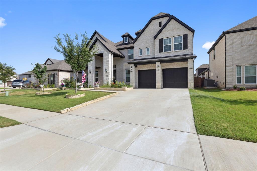 Undisclosed Address Wylie, TX 75098 - Photo 2 of 26 View of front of home with driveway, an attached garage, a front yard, and stone siding