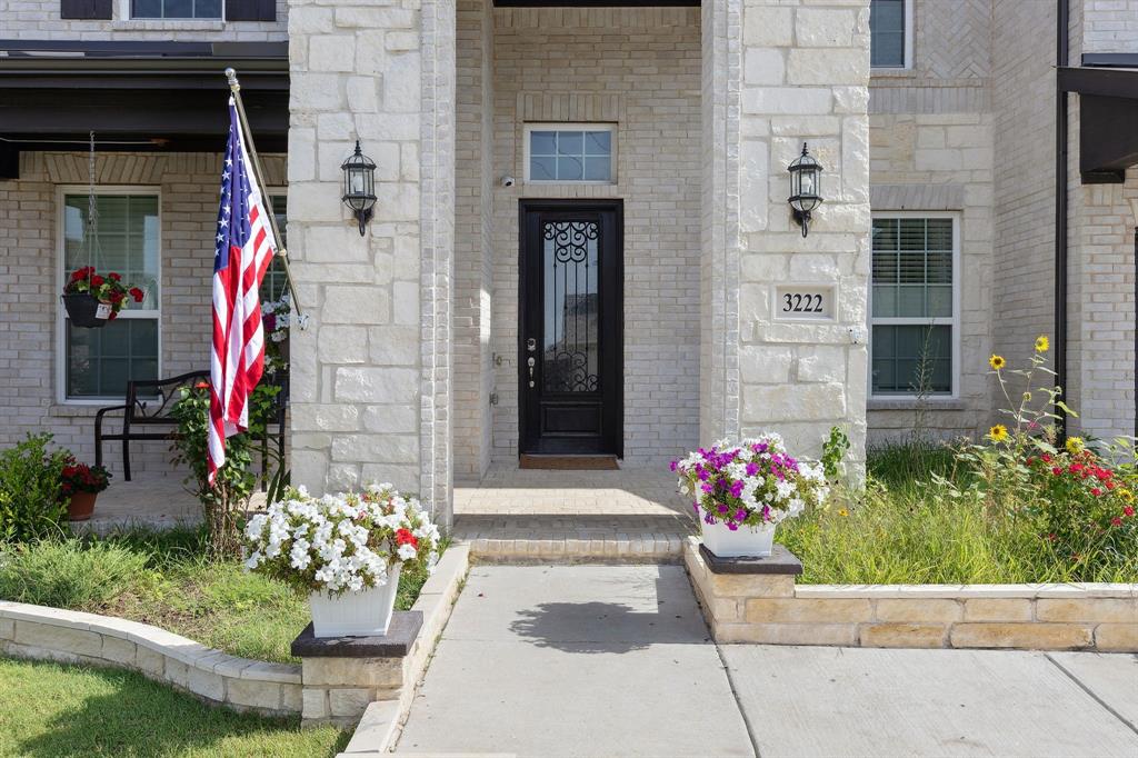 Undisclosed Address Wylie, TX 75098 - Photo 3 of 26 View of exterior entry featuring brick siding, stone siding, and covered porch