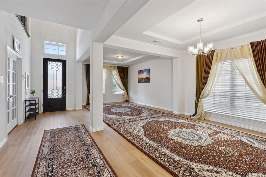 Undisclosed Address Wylie, TX 75098 - Photo 4 of 26 Entrance foyer with a chandelier, light wood-style flooring, and a tray ceiling