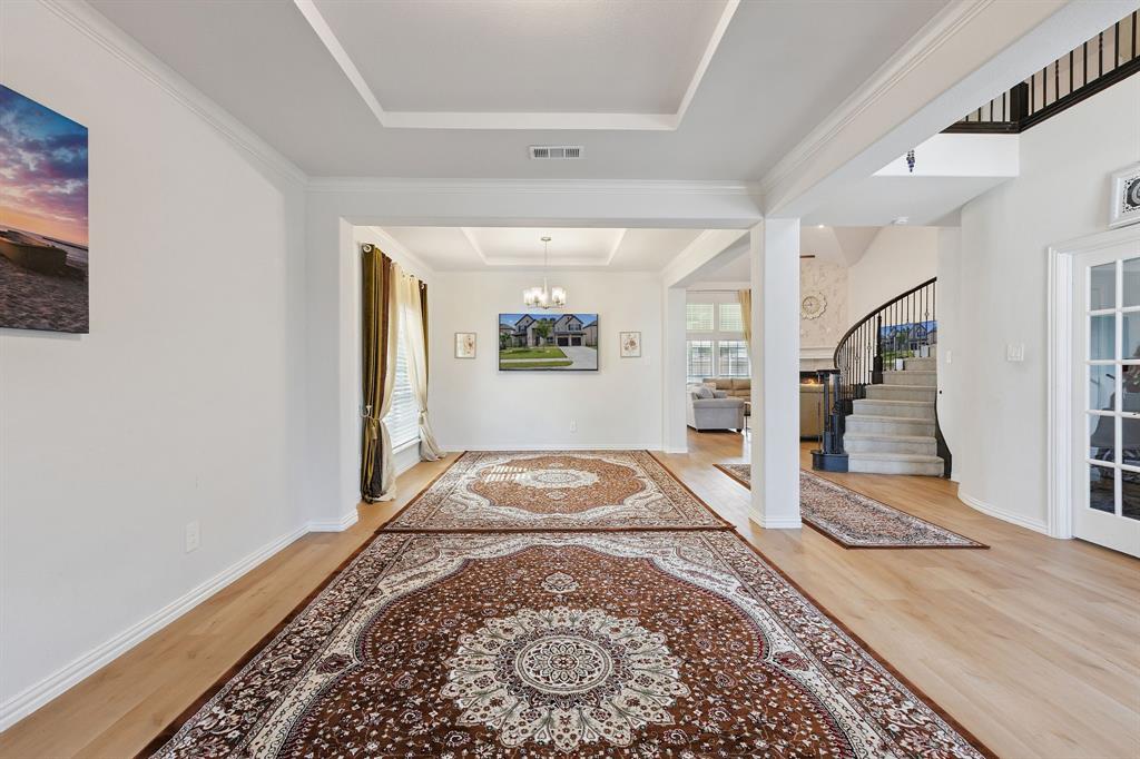 Undisclosed Address Wylie, TX 75098 - Photo 5 of 26 Formal Living/Dinning with light wood-style flooring, a chandelier, stairway, a raised ceiling, and crown molding
