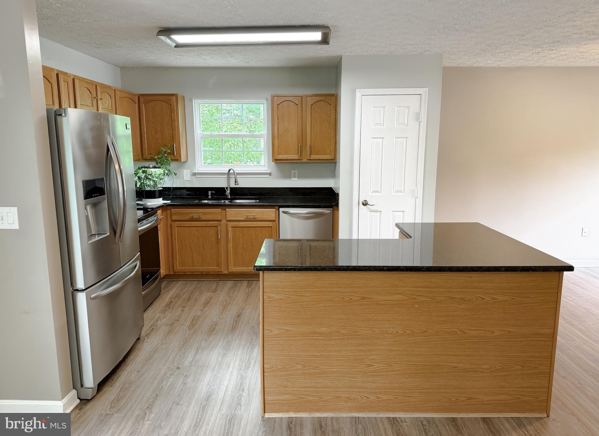 23801 McIntosh Road Hollywood, MD 20636 - Photo 11 of 35 a kitchen with stainless steel appliances granite countertop a refrigerator a sink a stove a microwave and island