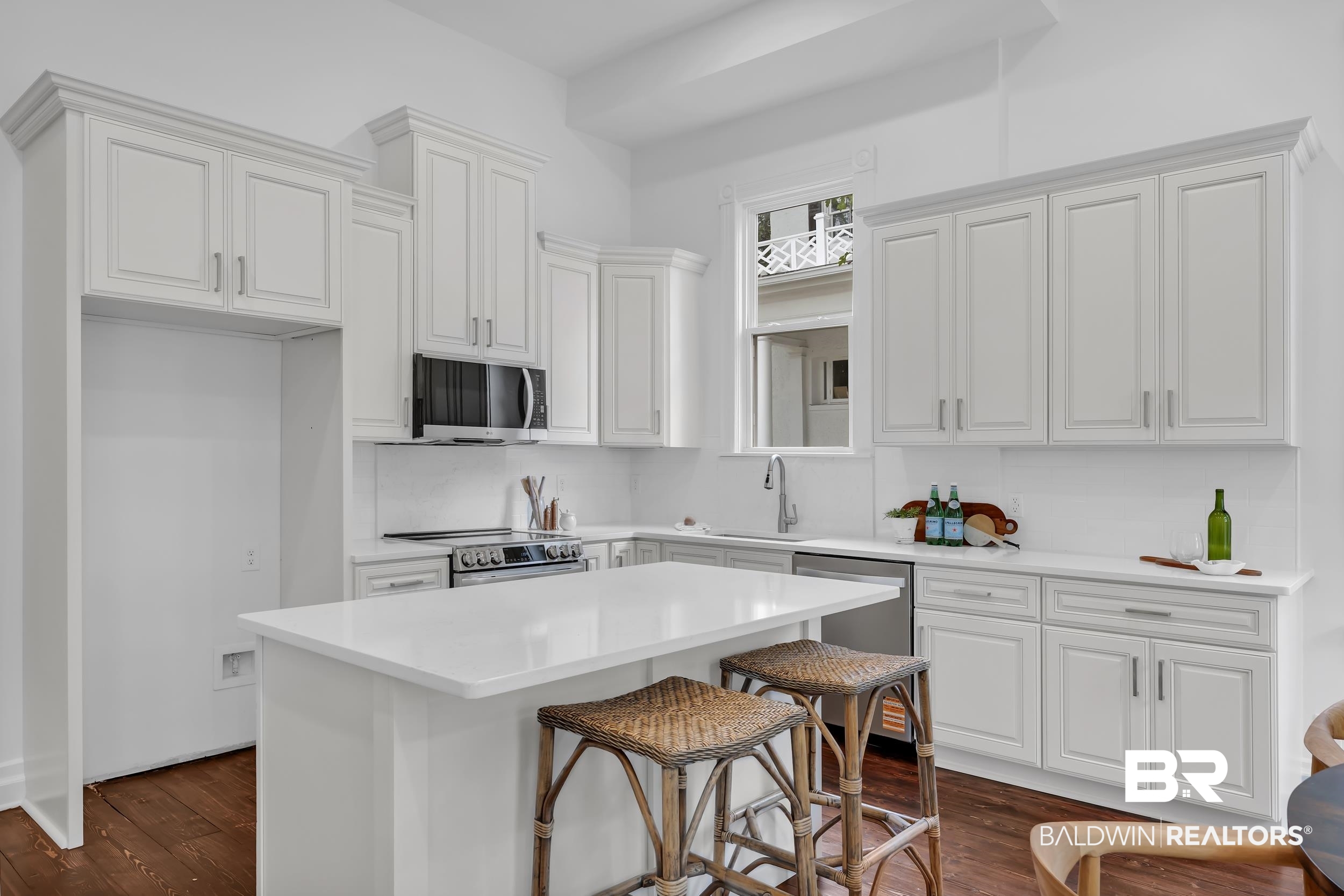 1662 Government Street Mobile, AL 36604 - Photo 12 of 33 Kitchen with appliances with stainless steel finishes, a breakfast bar area, dark wood-style flooring, and white cabinets