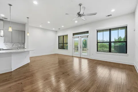 a view of a kitchen with wooden floor and a ceiling fan