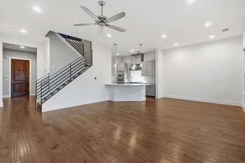 a kitchen with granite countertop stainless steel appliances a stove and a wooden floor