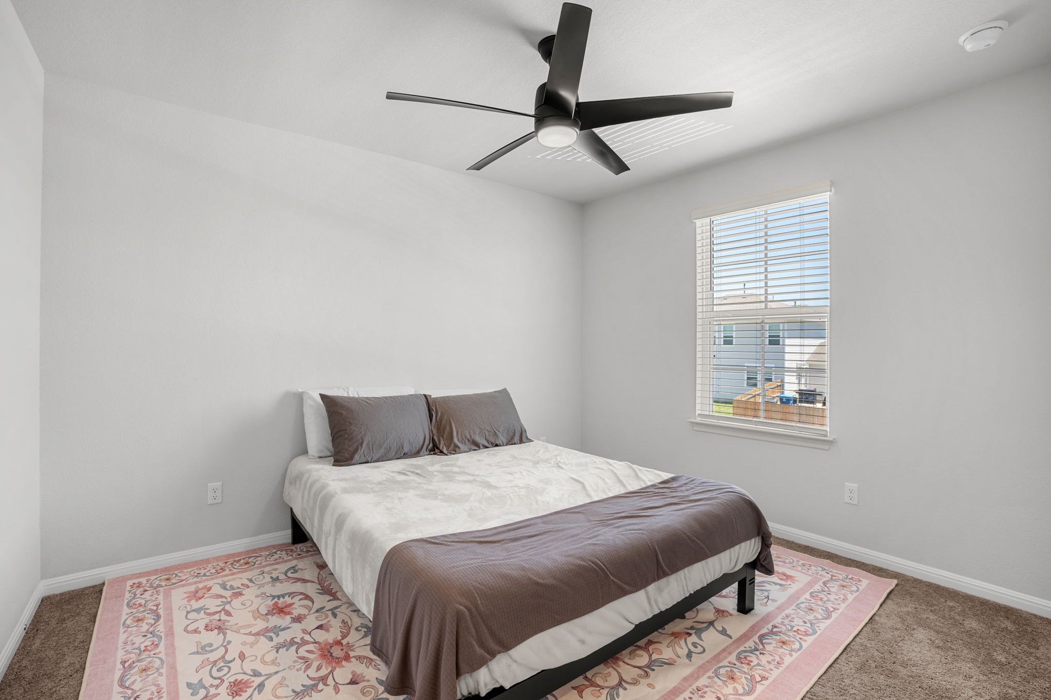 148 Hidalgo Lane Elgin, TX 78621 - Photo 27 of 38 A quiet bedroom retreat with plush carpeting and a large window, ready for personalization.