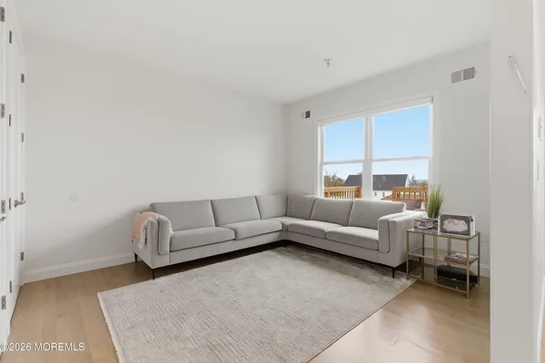 a living room with furniture a flat screen tv and a window