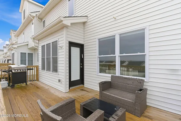 a view of a patio with couches chairs and wooden floor