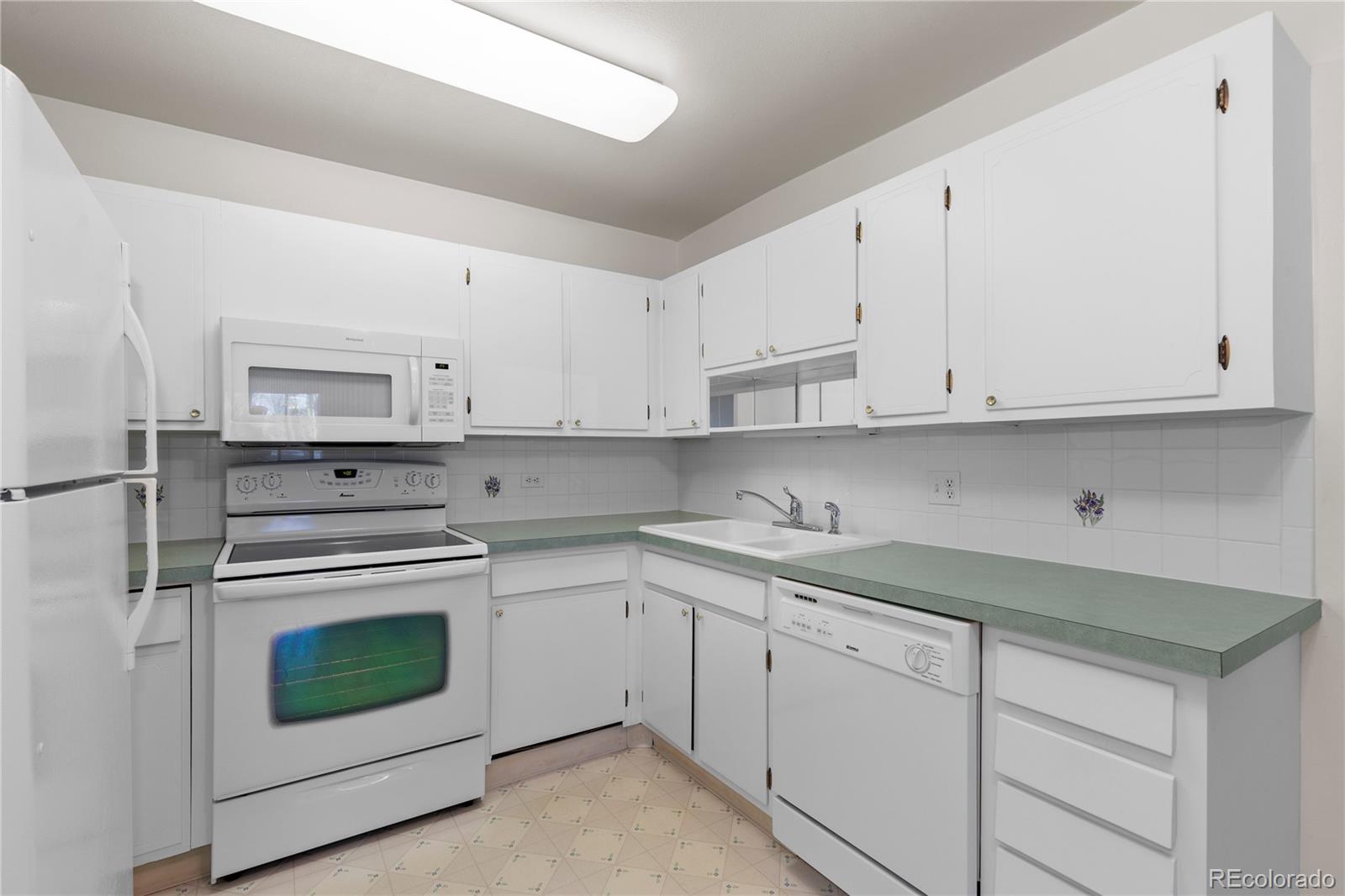 750 South Clinton Street, Unit 2B Denver, CO 80247 - Photo 13 of 43 a kitchen with cabinets appliances and a sink