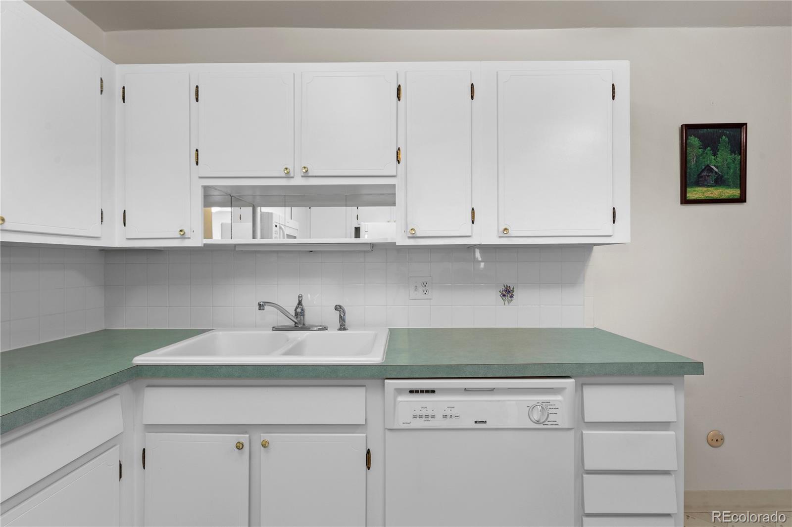 750 South Clinton Street, Unit 2B Denver, CO 80247 - Photo 14 of 43 a kitchen with white cabinets and a stove