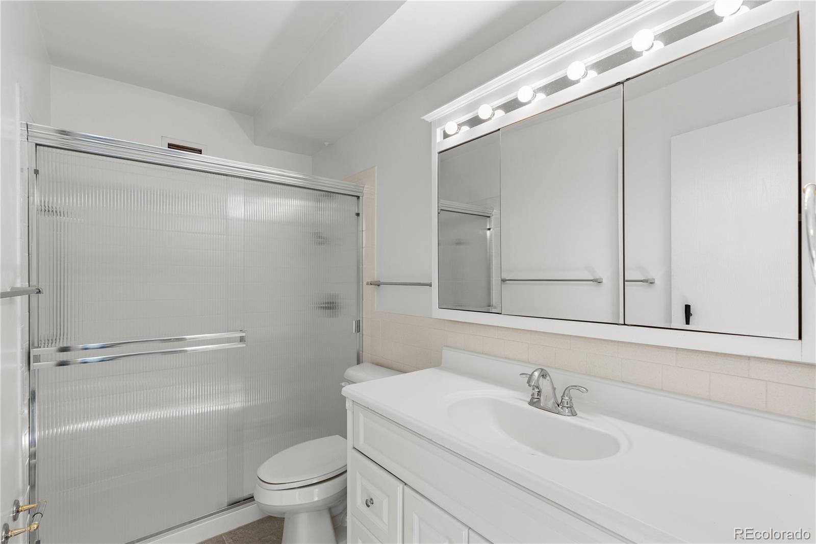 750 South Clinton Street, Unit 2B Denver, CO 80247 - Photo 20 of 43 a bathroom with a sink a mirror toilet and shower